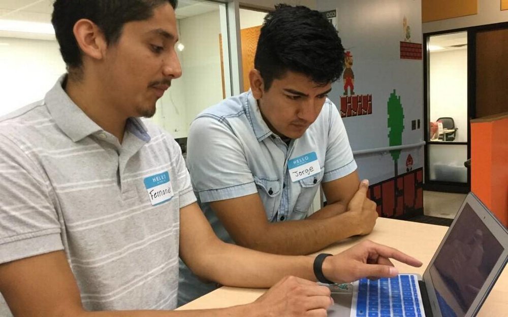  Fernando Osorto, left, and Jorge Rodriguez discuss an app they developed for Student Action with Farmworkers through the Code the Dream project sponsored by Uniting NC. Osorto and Rodriguez spoke at Code the Dream classes on July 29, 2017, at the American Underground in Durham, NC. 